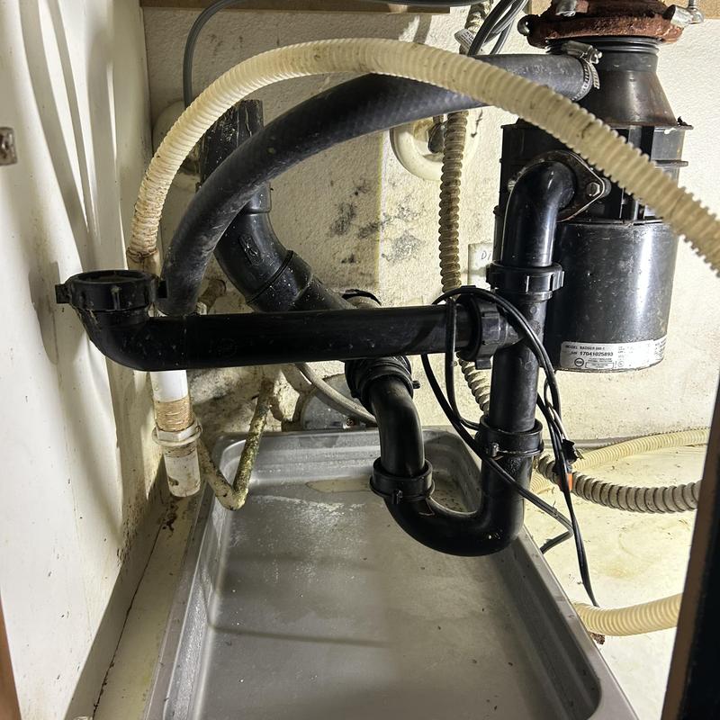 Garbage disposal and kitchen sink drain pipes under sink
