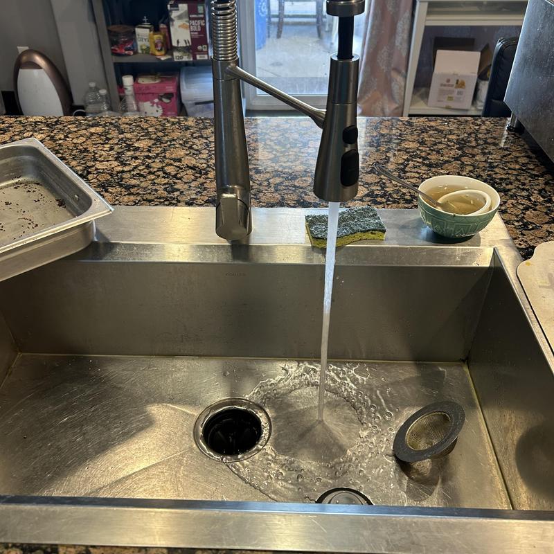 Kitchen sink drain clearing with running water flow