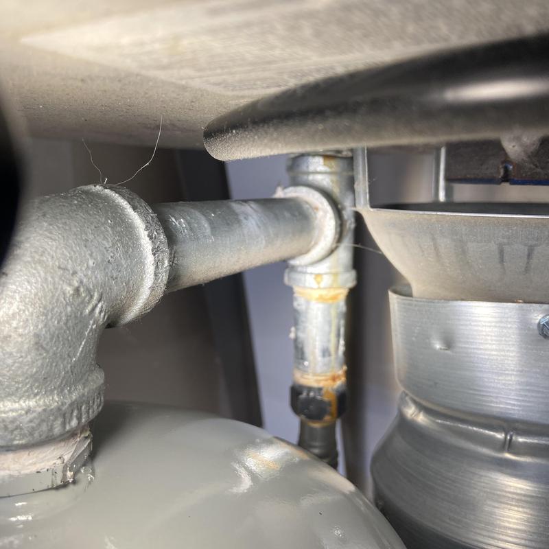 Natural gas line and vent pipe connection near heater