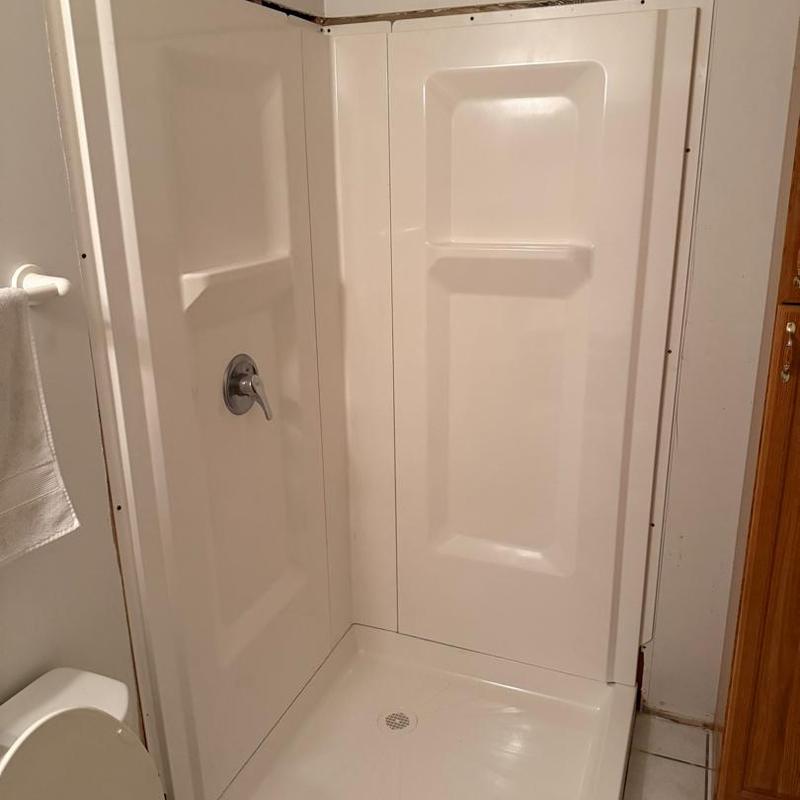 Corner shower stall installation in residential bathroom