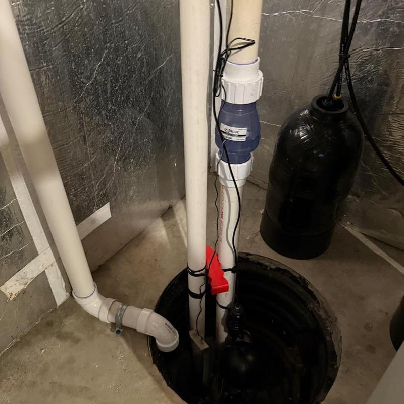 Backup sump pump system with discharge pipes and sensor