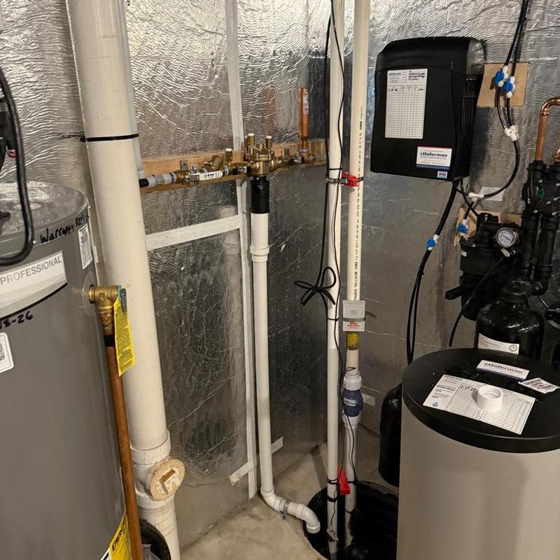 Backup sump pump installation in basement corner