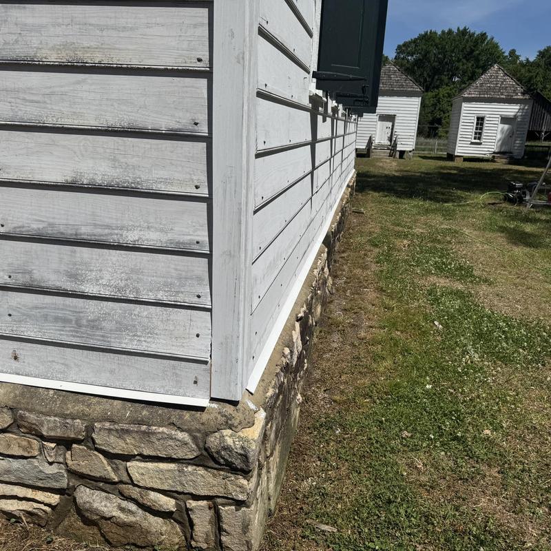 Cedar shake siding and metal flashing installation on foundation