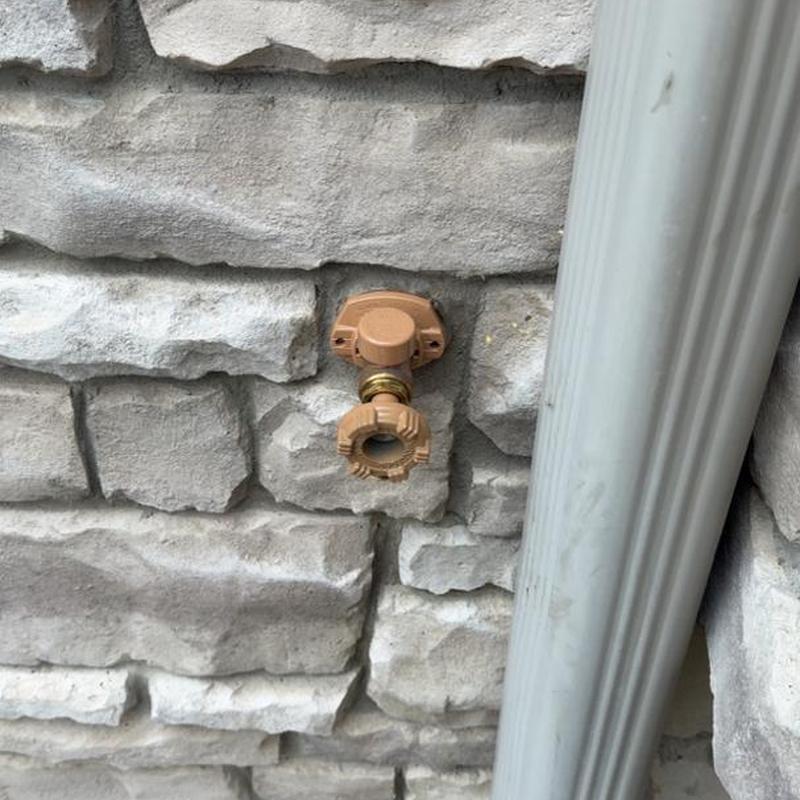 Outdoor spigot pipe replacement on stone wall