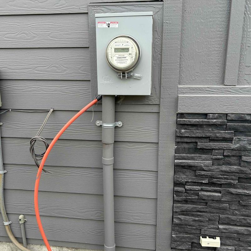 Electric meter box with orange power cable Electric meter box with orange power cable