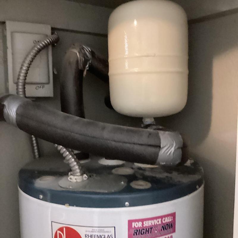 Thermal expansion tank atop water heater with taped pipes Thermal expansion tank atop water heater with taped pipes