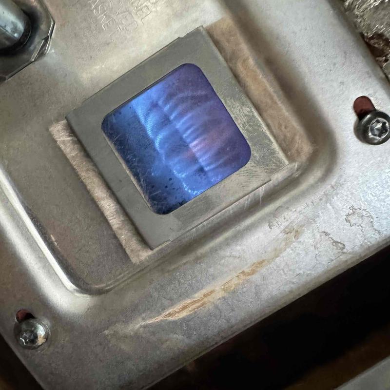 Gas water heater burner flame viewed through window Gas water heater burner flame viewed through window