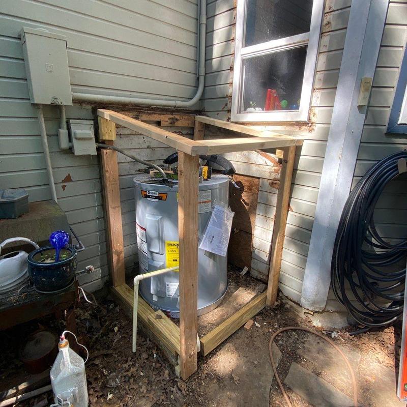 Exterior water heater framed with wooden shed structure Exterior water heater framed with wooden shed structure