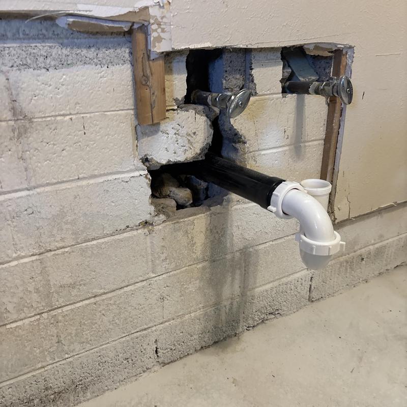PVC drain pipe installation in basement wall cavity