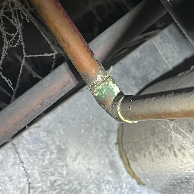 Copper water piping with corroded elbow joint in crawl space Copper water piping with corroded elbow joint in crawl space