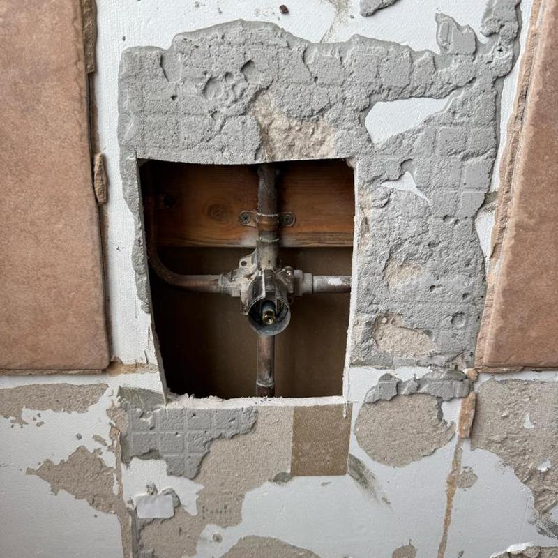Master bathroom shower valve and pipes exposed in wall cavity Master bathroom shower valve and pipes exposed in wall cavity