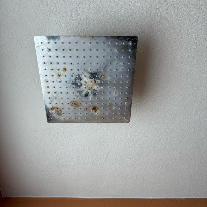 Rusty shower head installed on bathroom wall Rusty shower head installed on bathroom wall