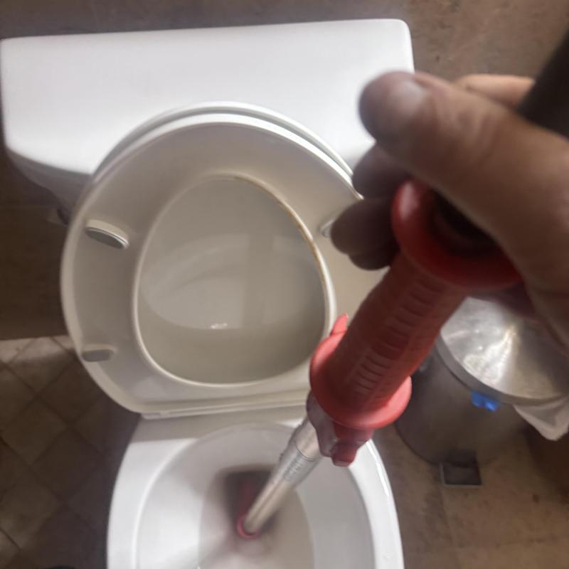 Toilet auger clearing blockage in Glendale, AZ bathroom