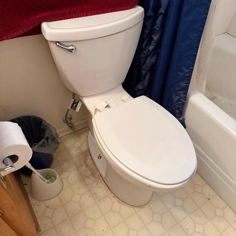 Toilet base leak with removed toilet seat in bathroom Toilet base leak with removed toilet seat in bathroom