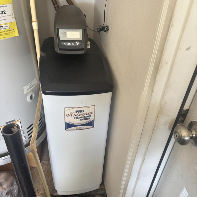 Water softener unit next to water heater in utility room