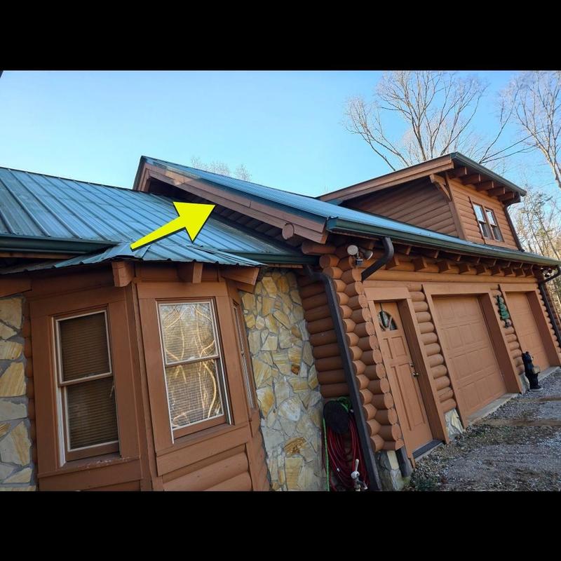 Metal roof section with leak inspection arrow