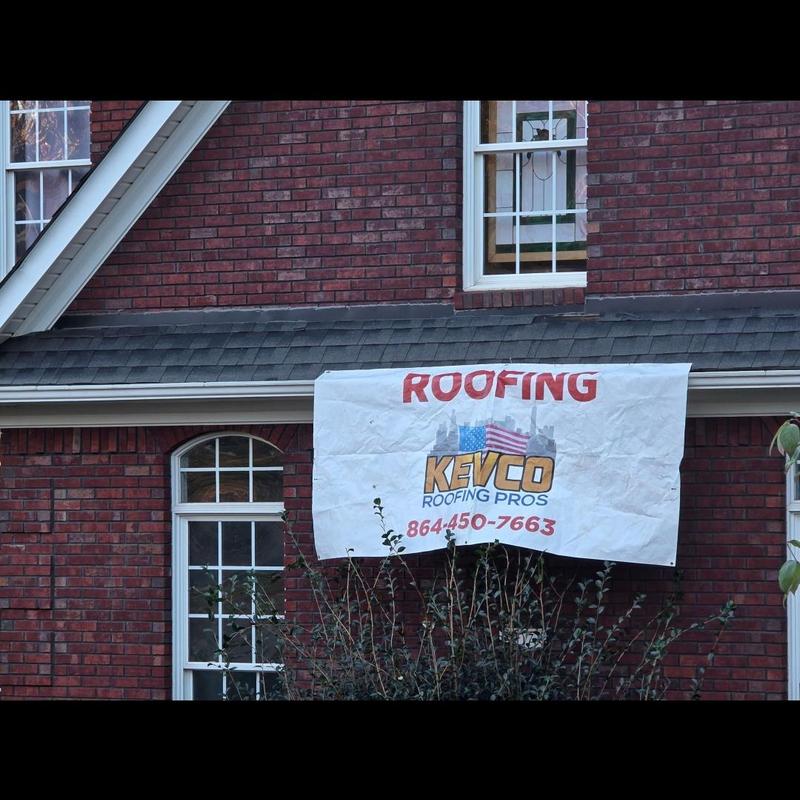 Gray asphalt shingle roof on red brick house