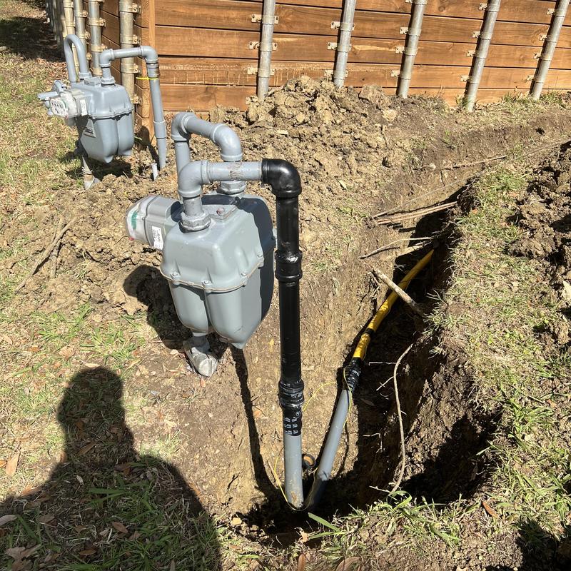 Main gas line with shut off valve and risers in trench