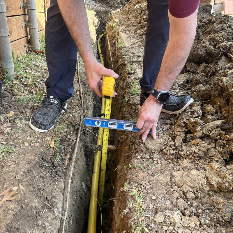 Main gas line trench with measuring tape and level