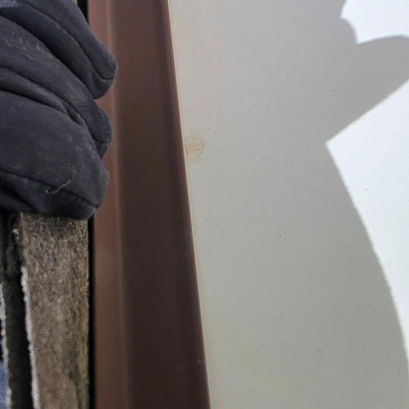 Metal roof flashing with rust spot and adjacent shingles