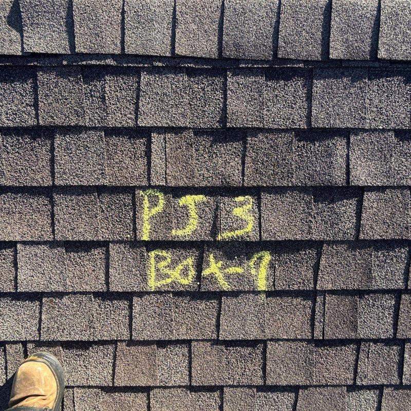 Shingle roof with yellow chalk damage markings