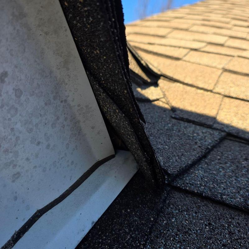Roof flashing with lifted and damaged shingles