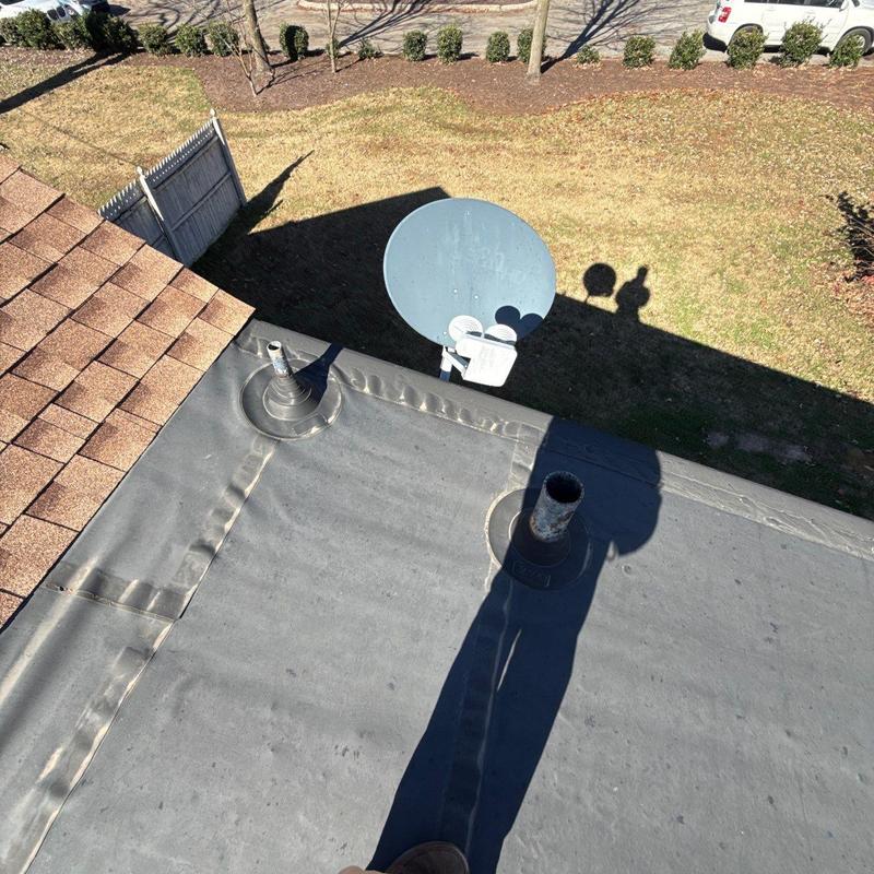 Flat roof membrane with vent pipe and satellite dish