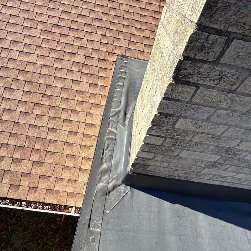 Chimney flashing and shingle roof with hail damage
