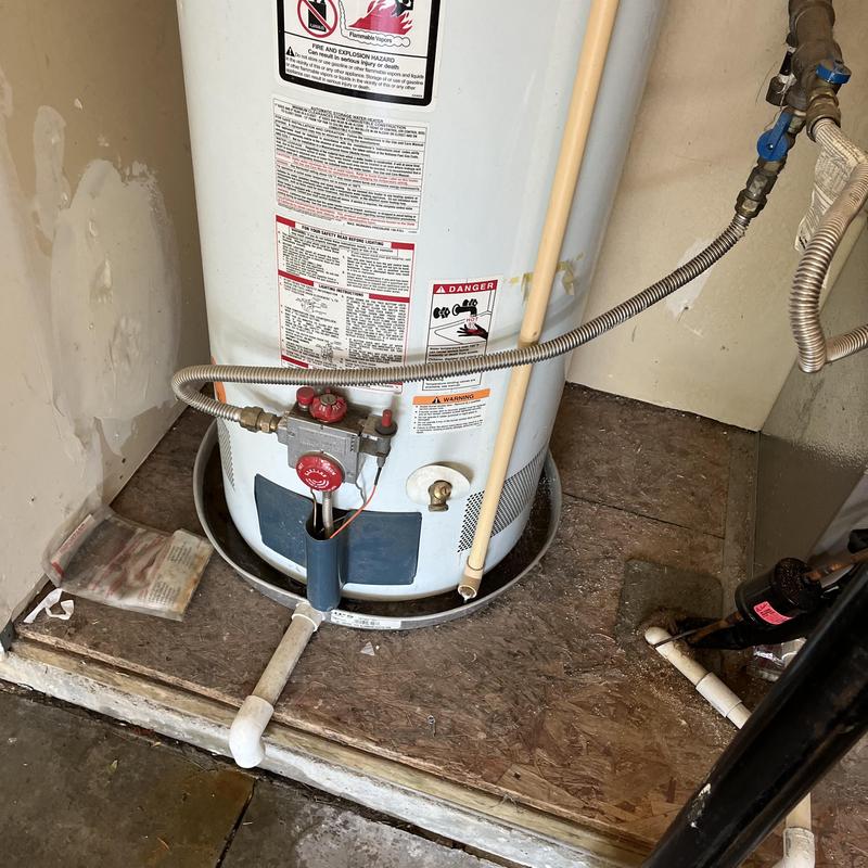 Water heater with corrosion at base in utility room
