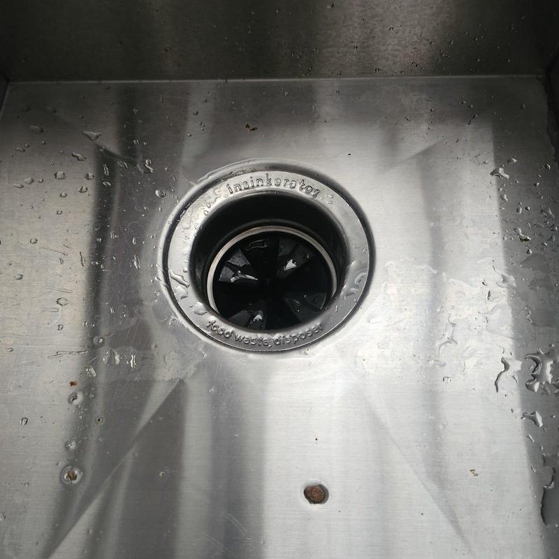 Garbage disposal drain port plug removed from sink