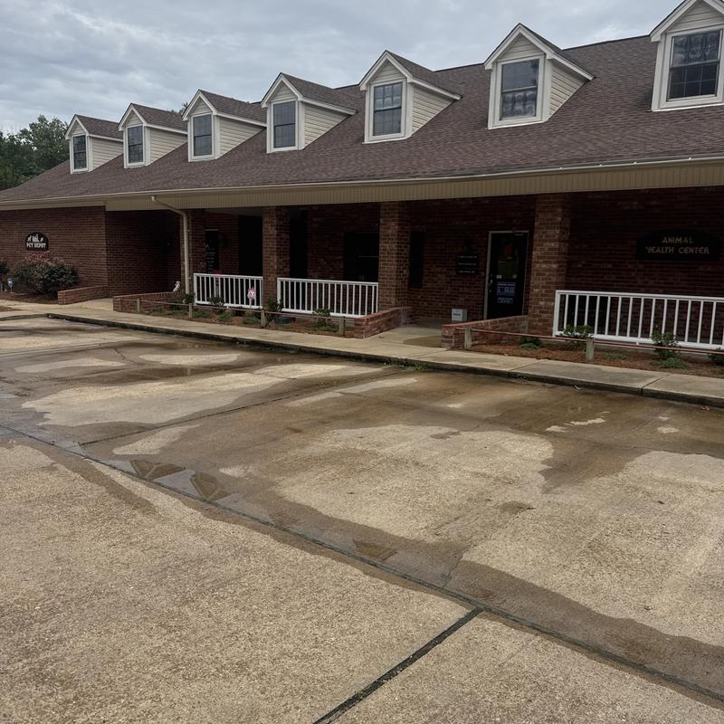 Concrete parking lot with surface wear near clinic building