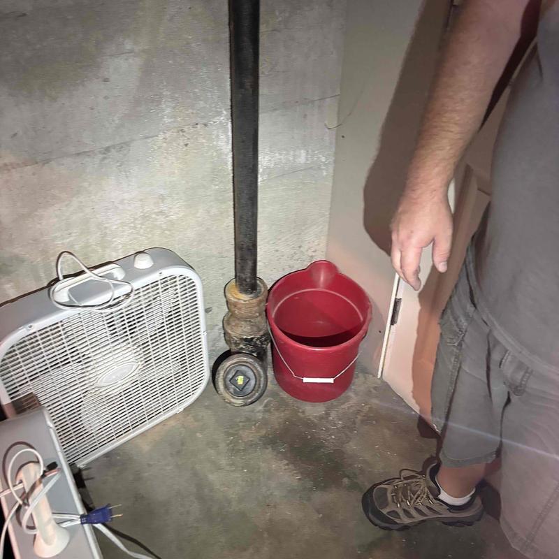 Sink drain cable line clearing with bucket and fan nearby