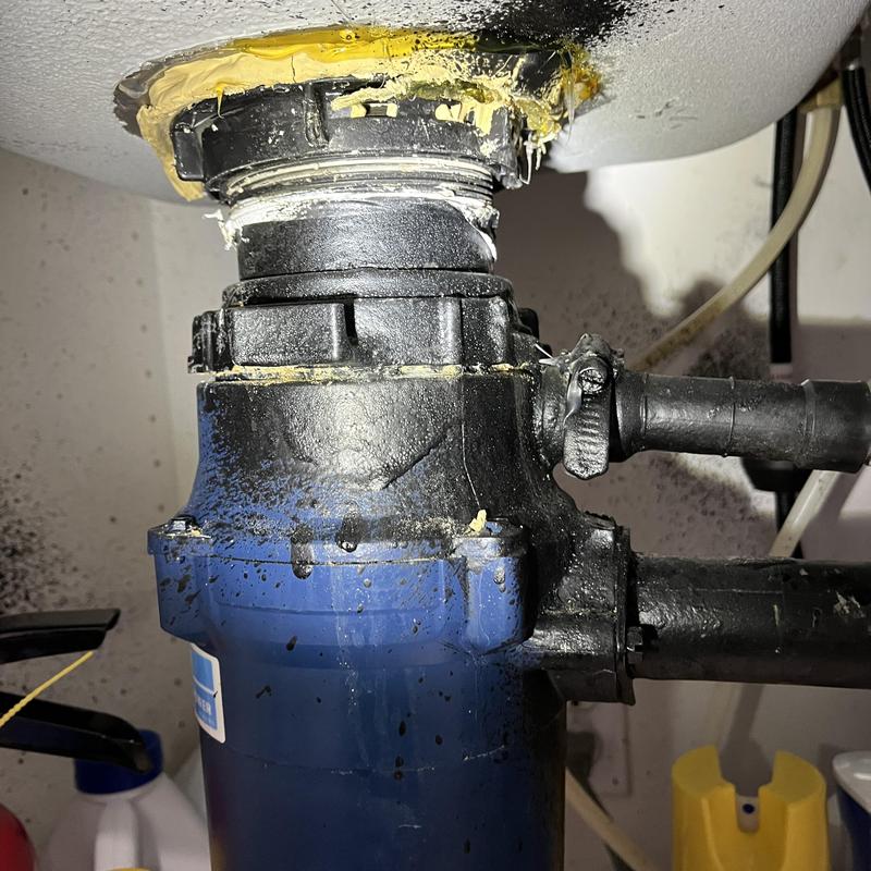 Garbage disposal with leaking and glue residue under sink Garbage disposal with leaking and glue residue under sink