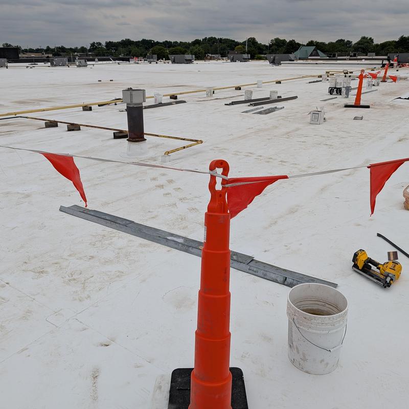 White commercial roof membrane with safety flags and tools