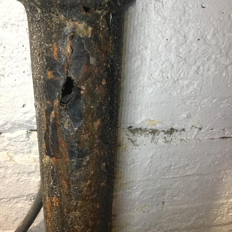 Cast iron drain pipe with hole and corrosion damage Cast iron drain pipe with hole and corrosion damage