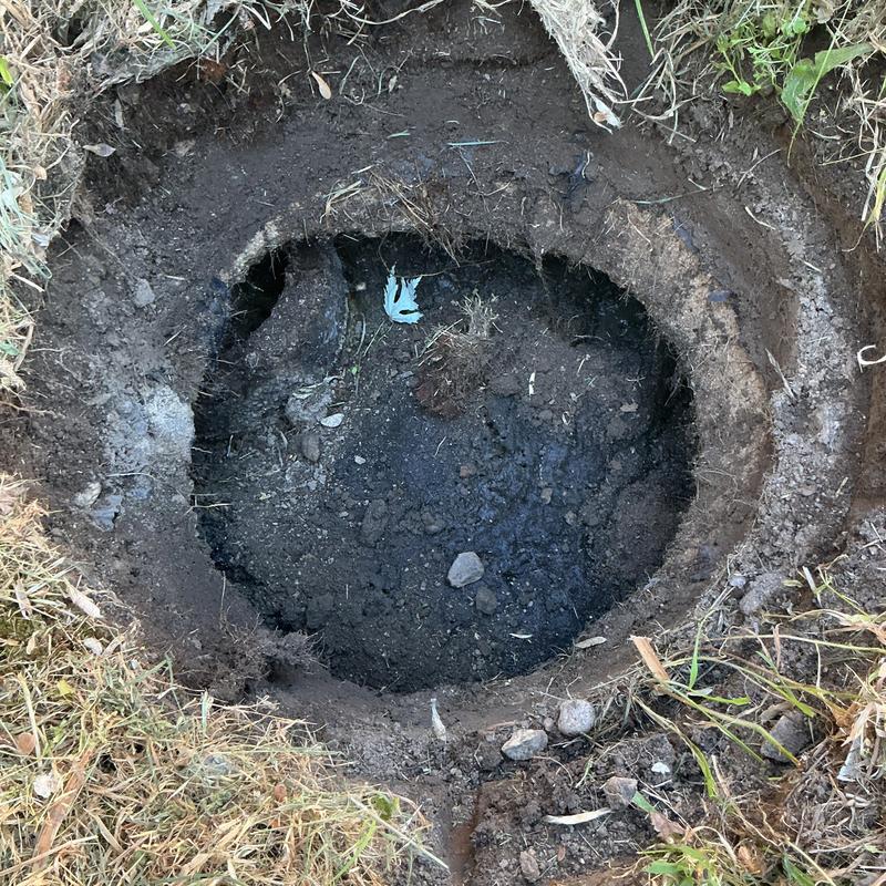 Septic tank excavation showing exposed soil and water