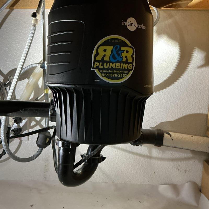 Garbage disposal unit with plumbing connections under sink