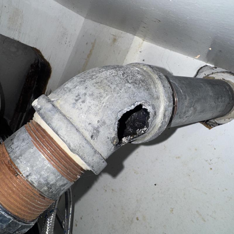 Galvanized drain pipe with hole before replacement