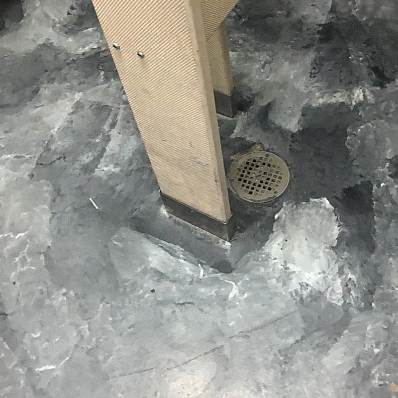 Floor drain clearing near stall partition base
