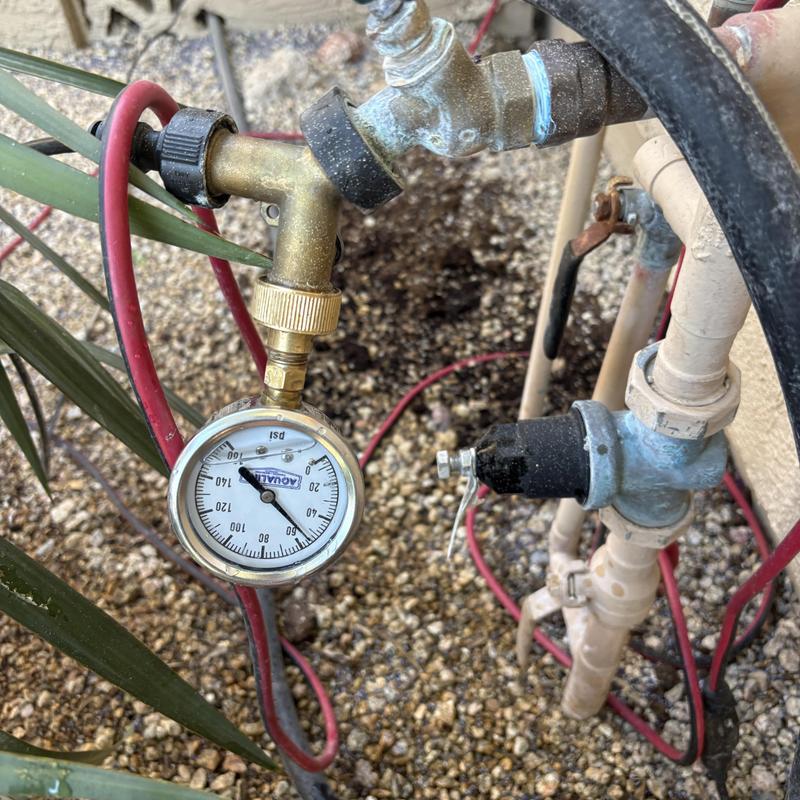 Pressure gauge on outdoor water supply valve setup