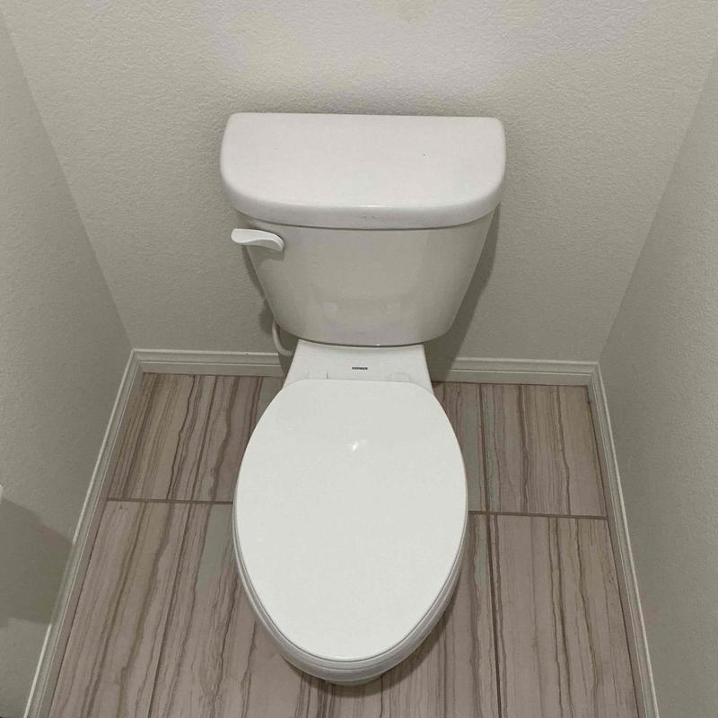 Pressure-assisted toilet installed on tile floor