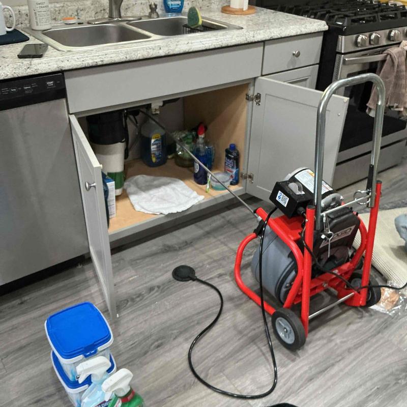 Kitchen drain line with drain snake clearing blockage