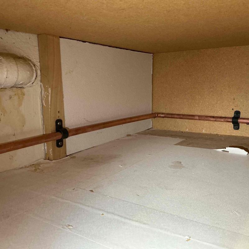 Copper water line routing through cabinet interior
