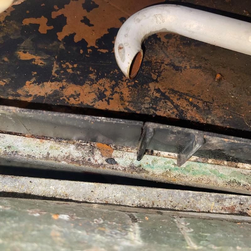 AC drain pan with visible cracks and residue