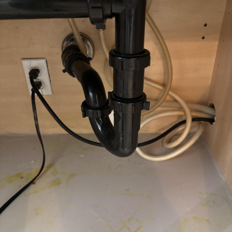 Sink p-trap drain line with cleaning access in cabinet