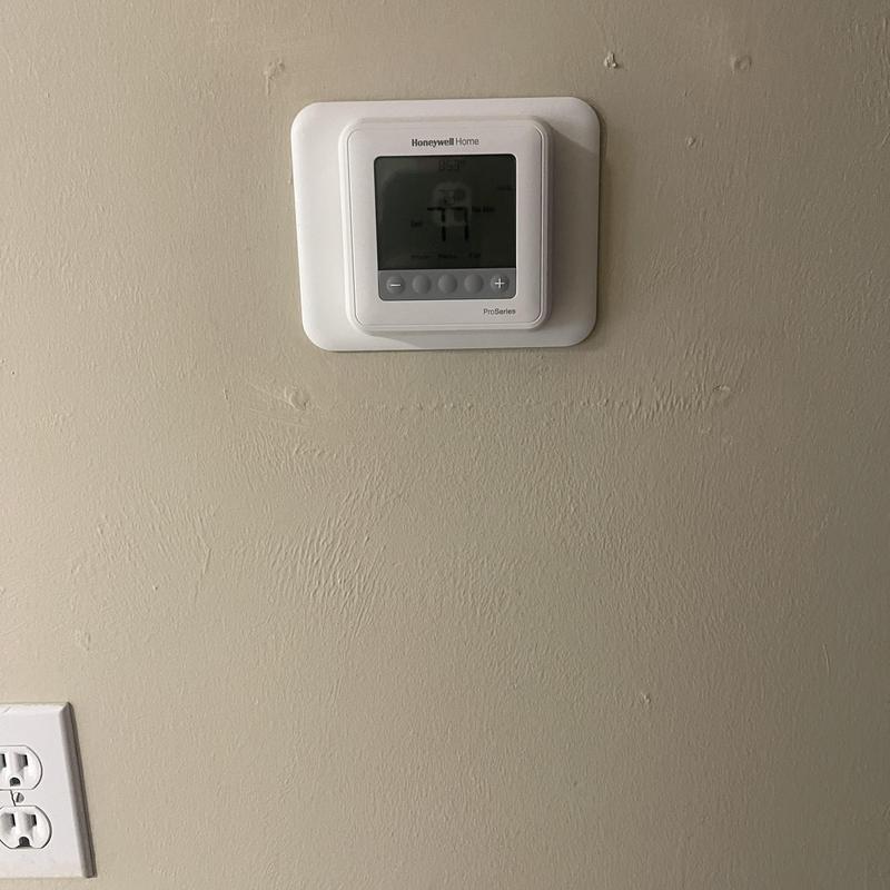 Digital thermostat upgrade installed on wall near outlet