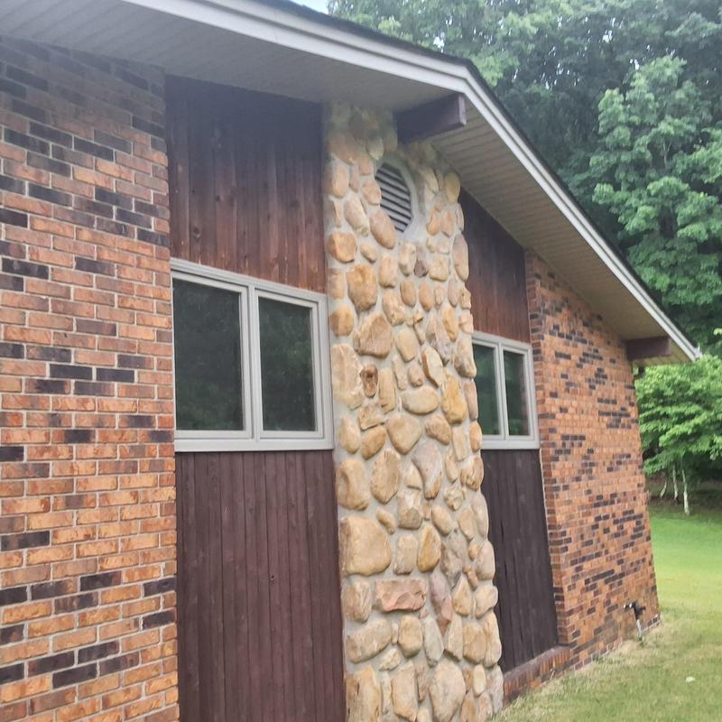 Stone chimney exterior with vent and siding adjacent Stone chimney exterior with vent and siding adjacent