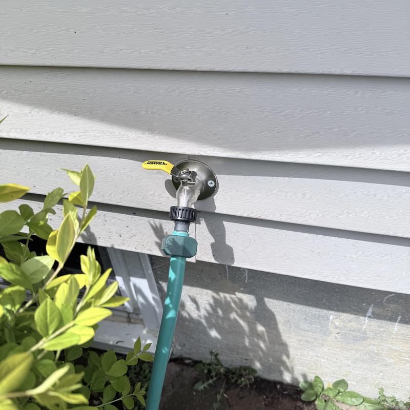 Silcock outdoor water faucet with hose attached