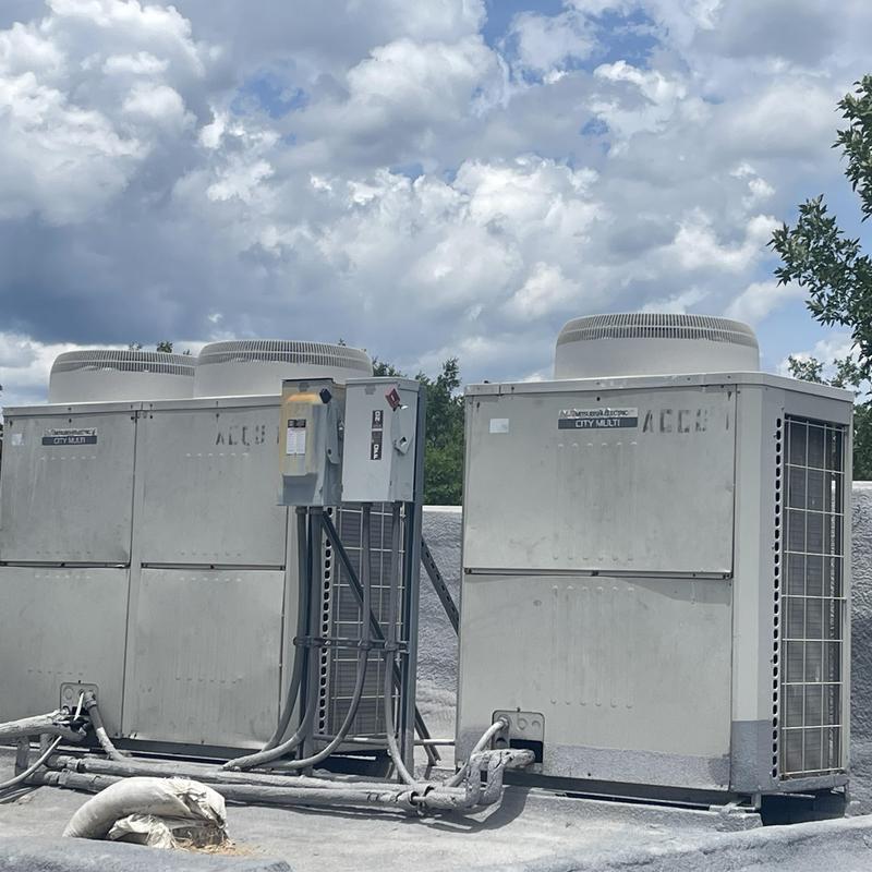 City Multi HVAC units on rooftop under cloudy sky