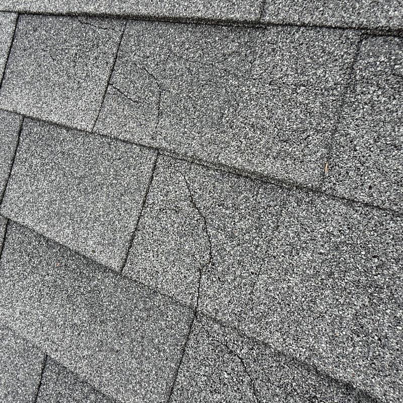 Asphalt shingle roof with visible cracks